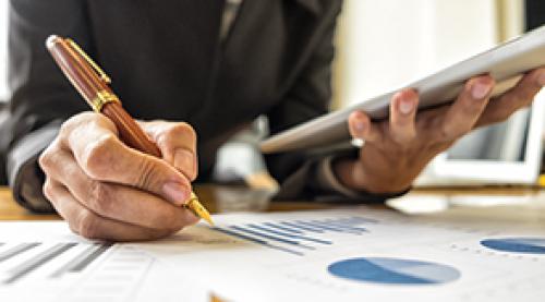 An image of one hand with a pen and the other hand holding a tablet